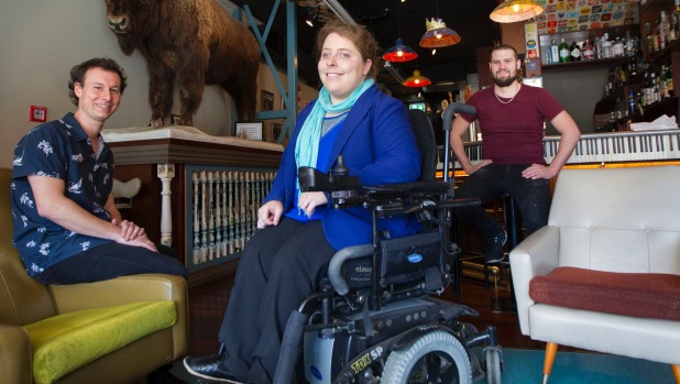 Photo Creidt: Ross Giblin/Fairfax. A photo of power chair user Erin Gough, who could not get into Slim Davey's pub on her first attempt, but was invited back by owner Davey McDonald and manager Rory Linstrom some weeks later after they provided a ramp in 